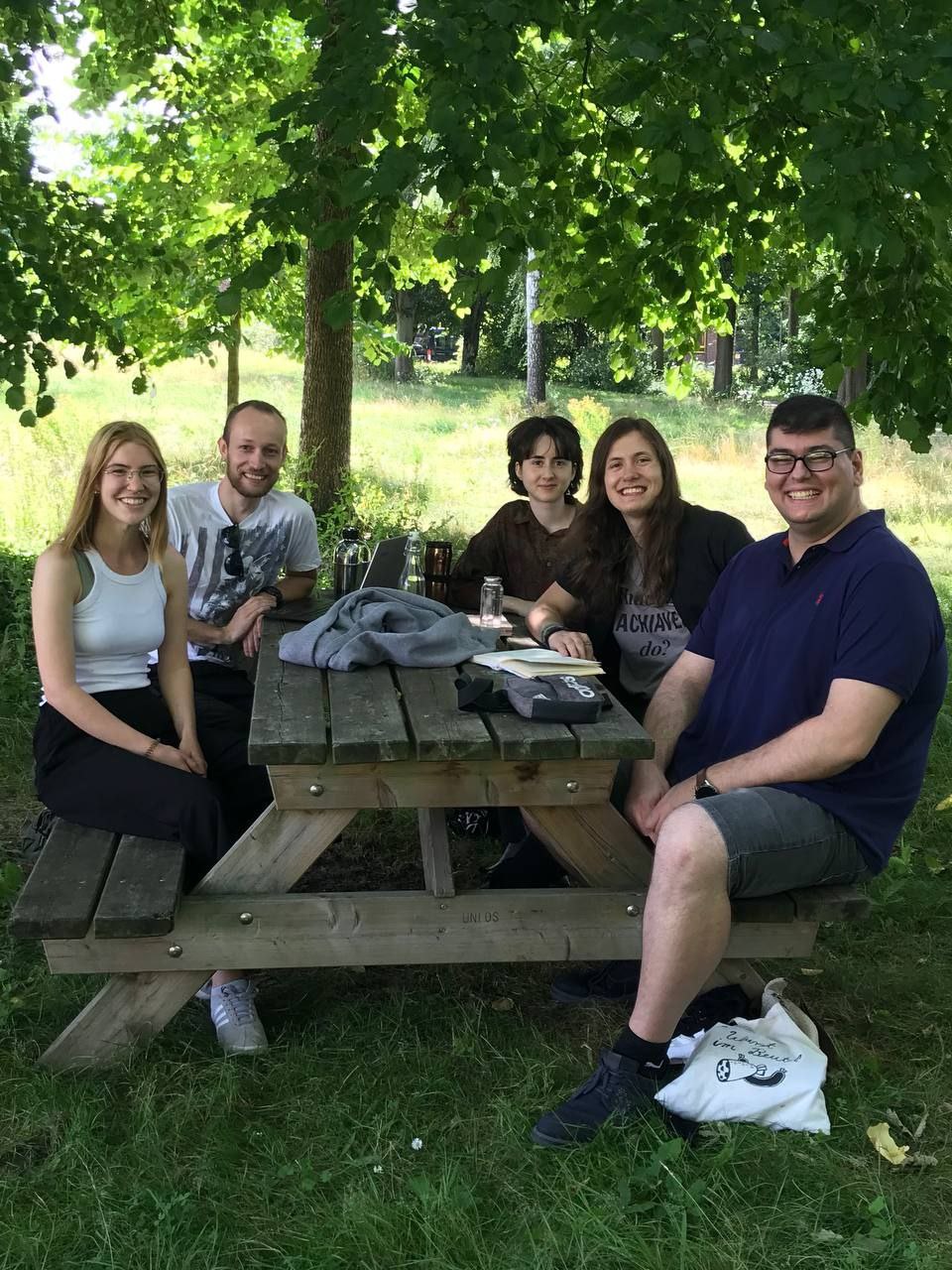 Eine Gruppe Studierende an einem Tisch im Institutsgarten. Von links nach rechts: Samara, Sean, Christina, Florian, Erkan